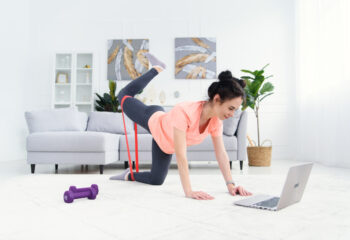 girl-trains-home-online-with-elastic-bands-fitness-online-home-training-woman-with-laptop-sports-home-quarantine